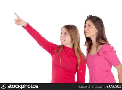 Two different sisters pointing something isolated on a white background