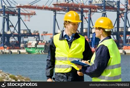 Two dockers at work in a big container harbor