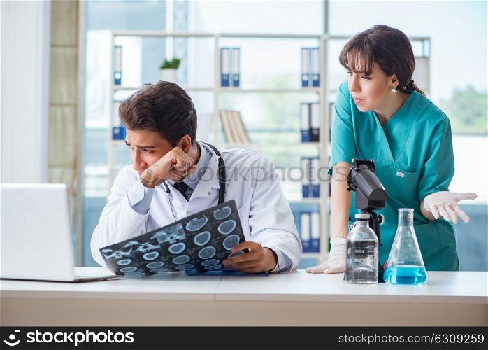 Two doctors discussing x-ray MRI image in hospital. The two doctors discussing x-ray mri image in hospital