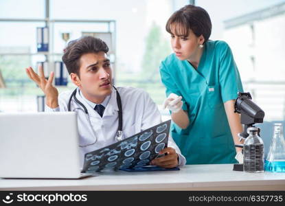 Two doctors discussing x-ray MRI image in hospital