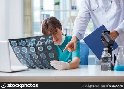 Two doctors discussing x-ray MRI image in hospital. The two doctors discussing x-ray mri image in hospital