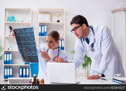 Two doctors examining x-ray images of patient for diagnosis