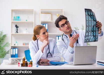 Two doctors examining x-ray images of patient for diagnosis