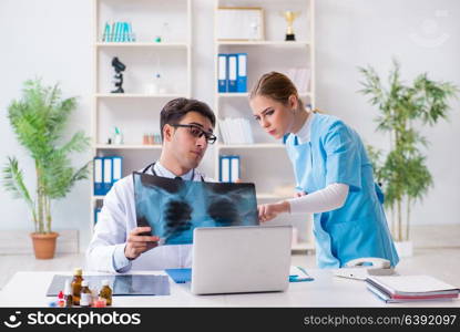 Two doctors examining x-ray images of patient for diagnosis