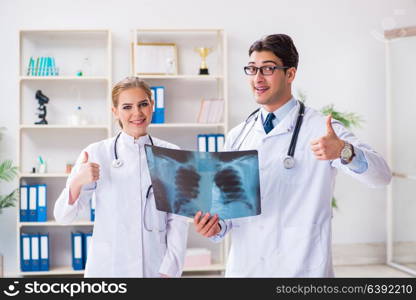 Two doctors examining x-ray images of patient for diagnosis