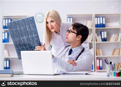 Two doctors examining x-ray images of patient for diagnosis