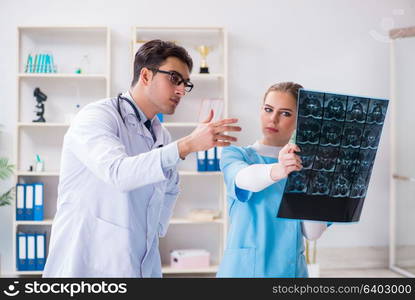 Two doctors examining x-ray images of patient for diagnosis