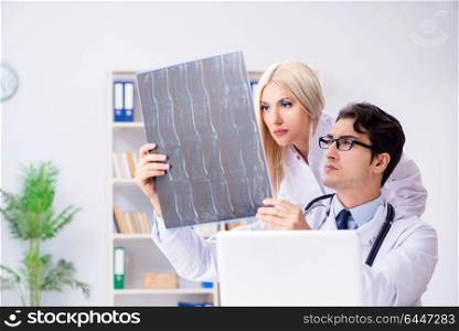 Two doctors examining x-ray images of patient for diagnosis