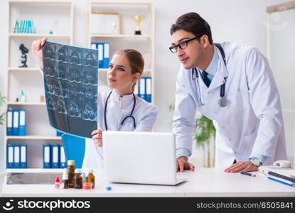 Two doctors examining x-ray images of patient for diagnosis