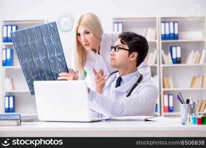 Two doctors examining x-ray images of patient for diagnosis