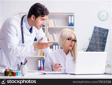 Two doctors examining x-ray images of patient for diagnosis. The two doctors examining x-ray images of patient for diagnosis
