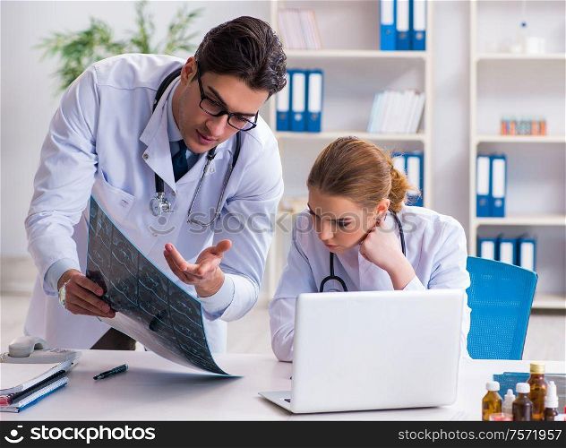 Two doctors examining x-ray images of patient for diagnosis. The two doctors examining x-ray images of patient for diagnosis