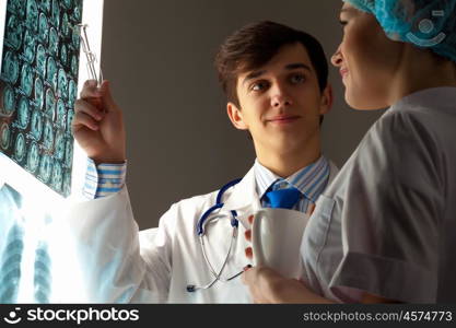 Two doctors examining x-ray results. Image of two young two doctors discussing x-ray results