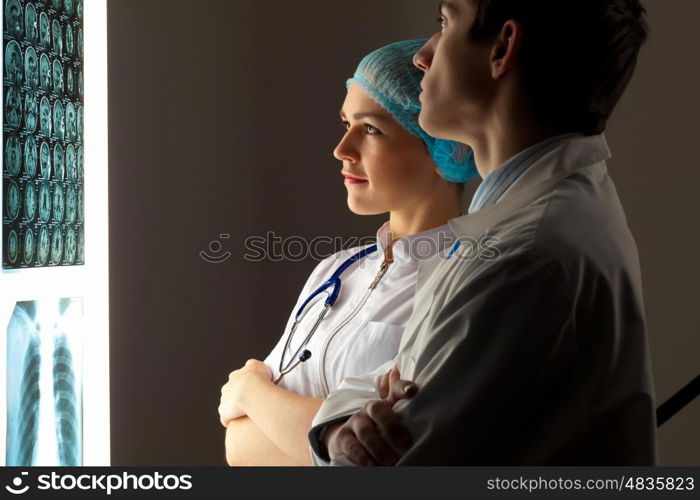 Two doctors examining x-ray results. Image of two young two doctors discussing x-ray results