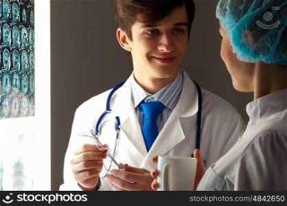 Two doctors examining x-ray results. Image of two young two doctors discussing x-ray results