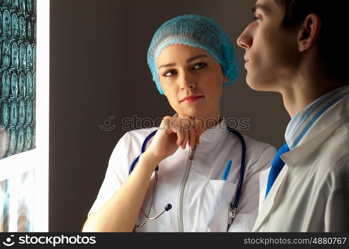 Two doctors examining x-ray results. Image of two young two doctors discussing x-ray results
