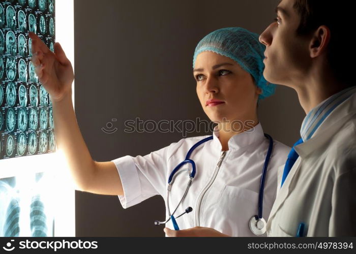 Two doctors examining x-ray results. Image of two young two doctors discussing x-ray results