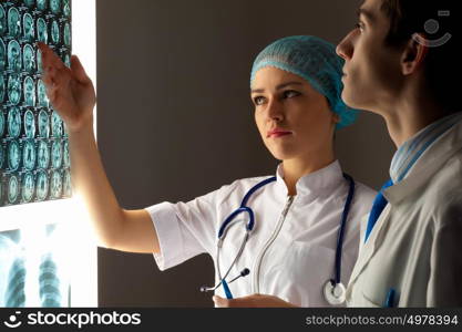 Two doctors examining x-ray results. Image of two young two doctors discussing x-ray results