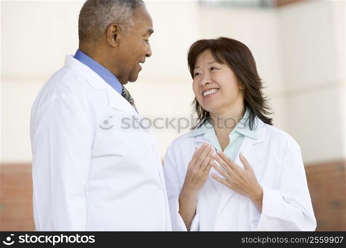 Two Doctors Standing Outside A Hospital