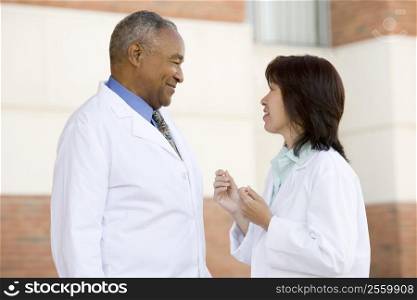 Two Doctors Standing Outside A Hospital