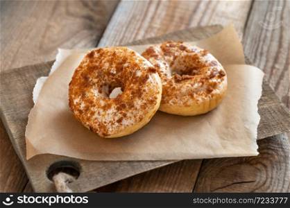 Two donuts on the wooden board