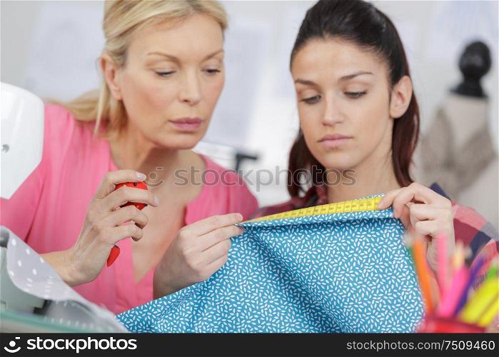 two dressmaker looks at a nice piece of fabric