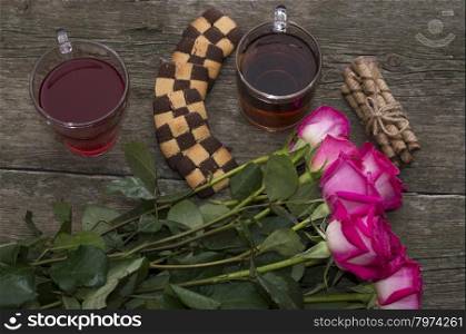 two drinks, cookies and bouquet of brightly red roses, top view, subject drinks and flowers