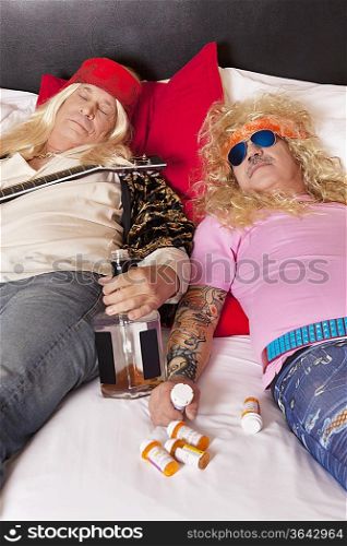Two drunk male friends reclining on bed