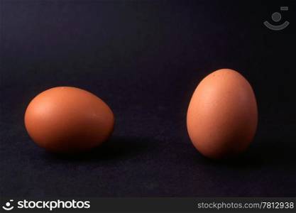 Two eggs isolated on black background