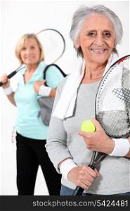 Two elderly women playing tennis