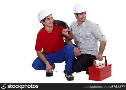 Two electrician kneeling