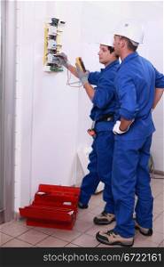 Two electricians inspecting electrical, power supply