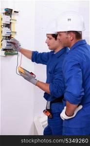 Two electricians performing checks