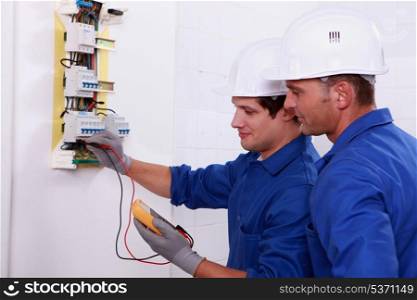 Two electricians performing checks