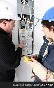 Two electricians repairing fuse box
