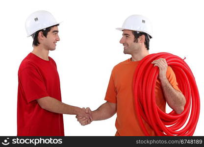 Two electricians shaking hands