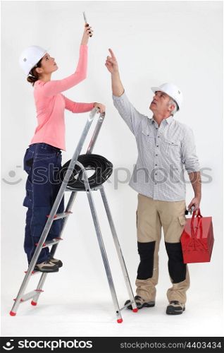 Two electricians working on ceiling lighting