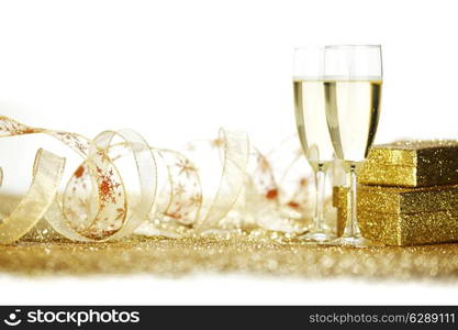 Two elegant flutes of sparkling champagne with decorative golden gifts