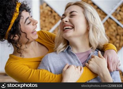 two embraced women laughing together
