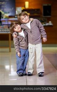 Two embracing little boys in grocery shop