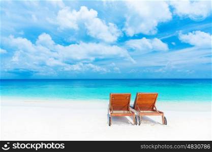 Two empty sunbed on the beach, beautiful seascape, relaxation on Maldives island, luxury summer vacation concept