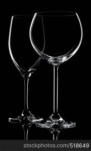 Two empty wine glasses on a black background