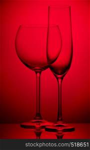 Two empty wineglasses on a red background