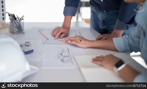 Two engineer architect discussion and inspecting sketching about interior architectural building on blueprint to analysis technical for construction plan while working together in workplace site.