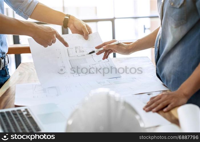 two engineers discussion on architectural project at construction site at modern office