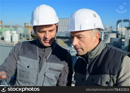 two factory workers discussion and pointing for inspection