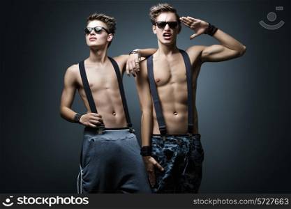 Two fashionable guy in glasses on a dark blue background