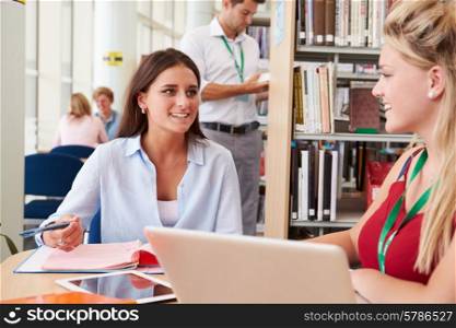 Two Female College Students Studying In Library Together