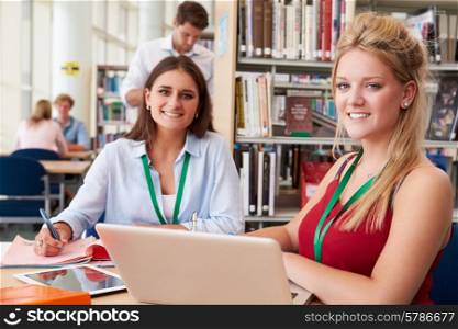 Two Female College Students Studying In Library Together