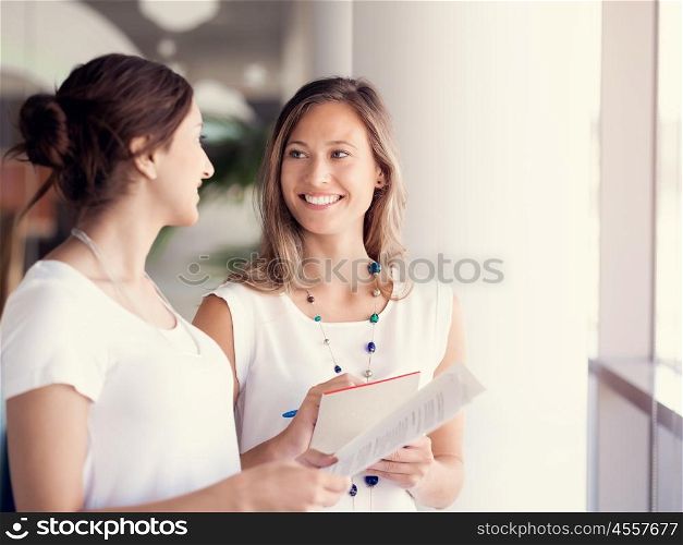Two female collegues standing next to each other in an office